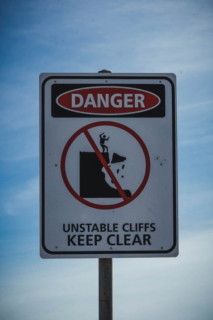 a sign warning of danger of unstable cliffs