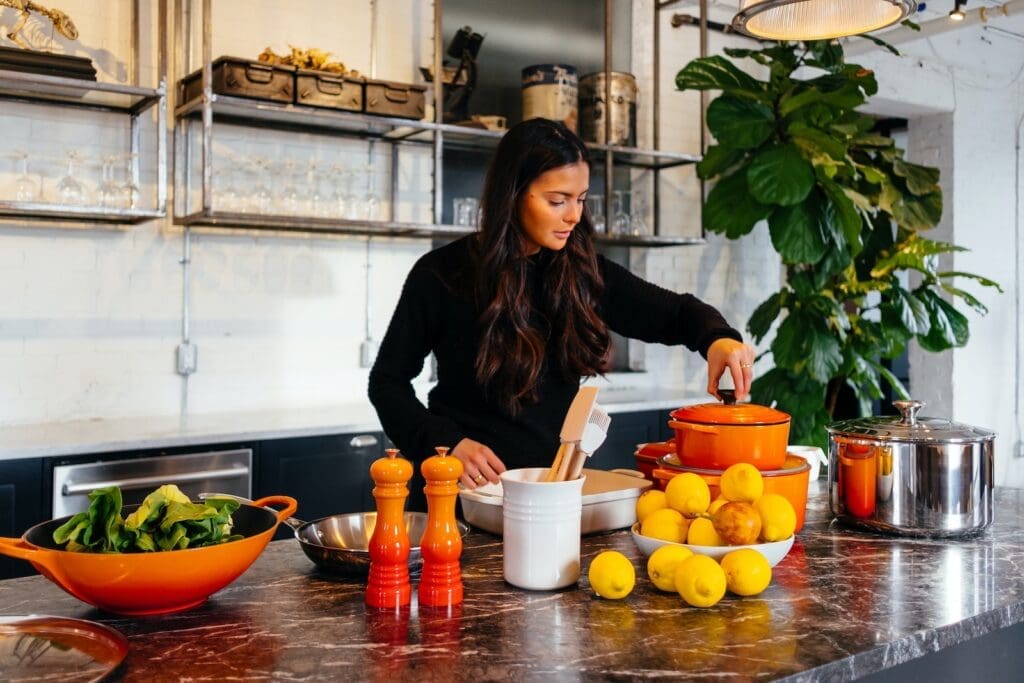 Health influencers woman standing in front of fruits holding pot's lid