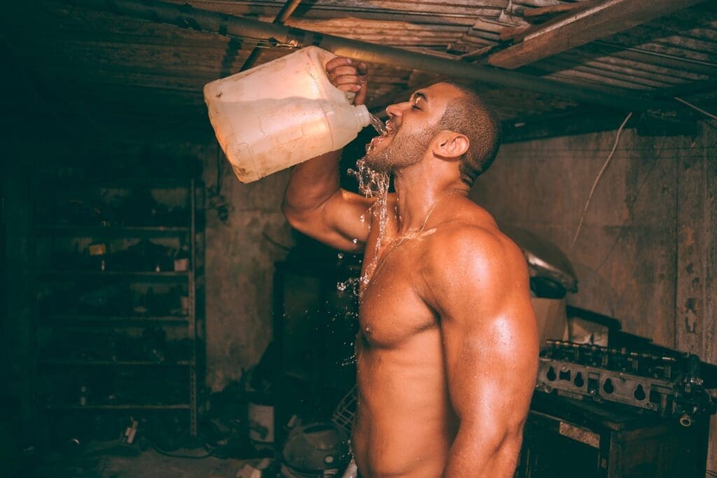 Men's Health Week 2023: Fitness & Nutrition topless man drinking water from plastic container